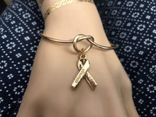 Charger l'image dans la galerie, Bracelet Octobre Rose. Bracelet jonc Noeud avec Un Ruban doré et l'inscription Courage. BRACELET Cancer