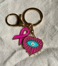 Charger l&#39;image dans la galerie, Porte clé bijou de sac octobre rose en acier inoxydable doré à l’or fin coeur avec un œil et ruban rose vif
