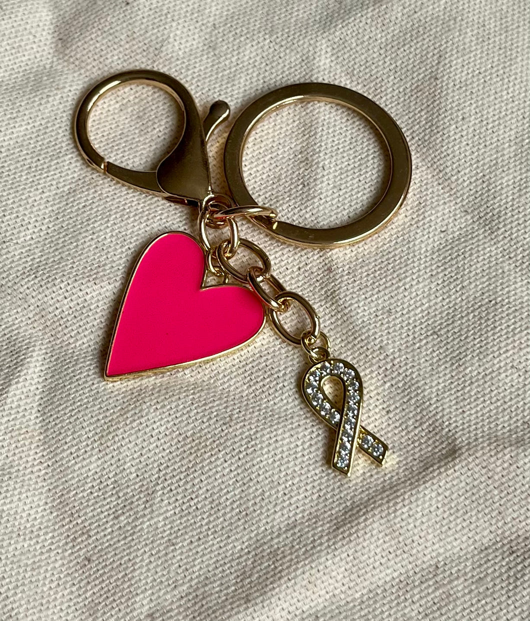 Porte clé bijou de sac octobre rose en acier inoxydable doré à l’or fin avec ruban strass or