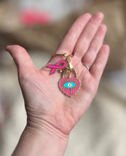 Charger l&#39;image dans la galerie, Porte clé bijou de sac octobre rose en acier inoxydable doré à l’or fin coeur avec un œil et ruban rose vif
