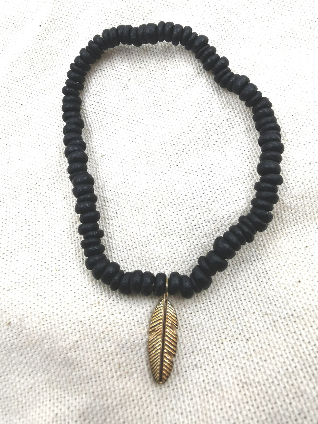 Bracelet INDIANA avec perle en bois et pendentif plume doré